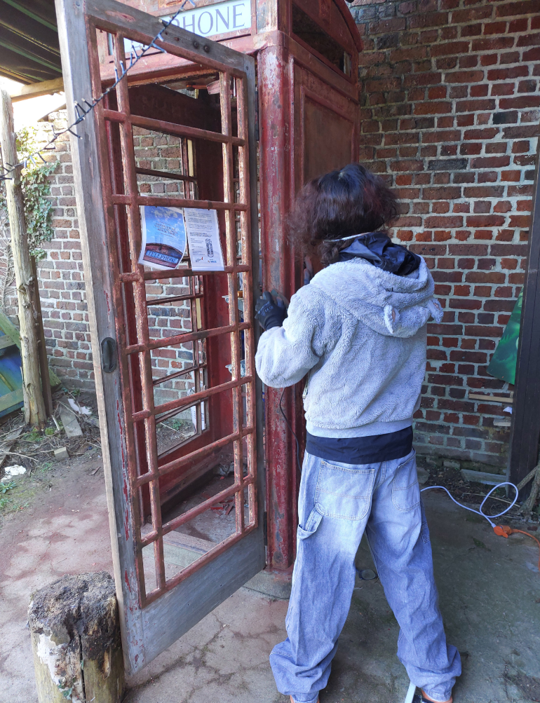 Jongere werkt aan telefooncel